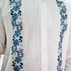 Detalle del bordado floral azul en guayabera