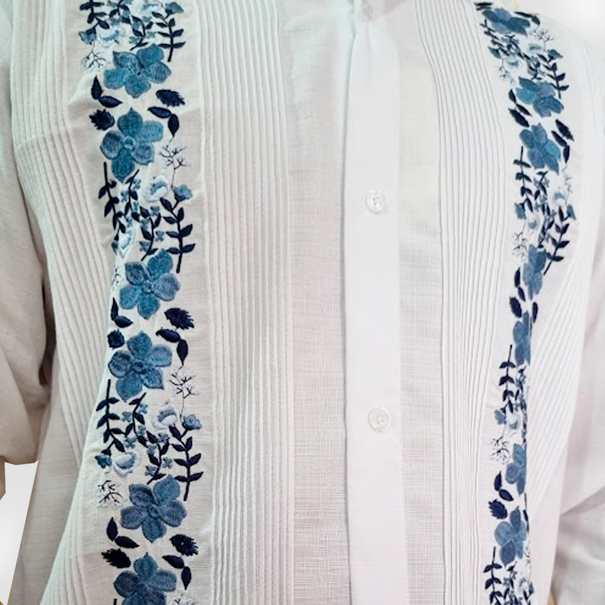 Detalle del bordado floral azul en guayabera