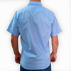 Camisa guayabera azul claro combinada con pantalones de lino blancos