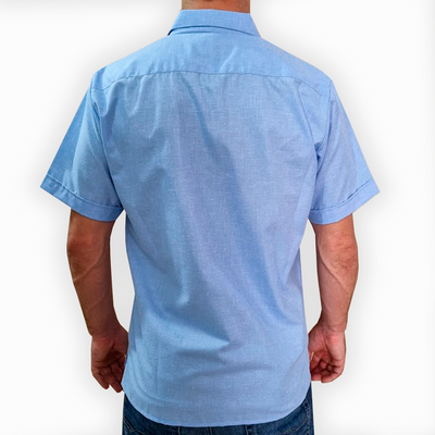 Camisa guayabera azul claro combinada con pantalones de lino blancos