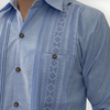 Detalle de bordado azul tradicional en guayabera