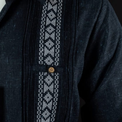 Detalle de bordado blanco artesanal en guayabera azul marino
