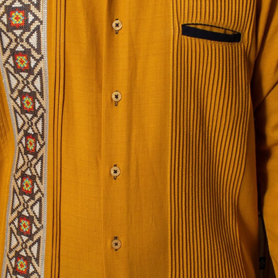 Detalle de las alforzas y bolsillos de la guayabera amarilla.