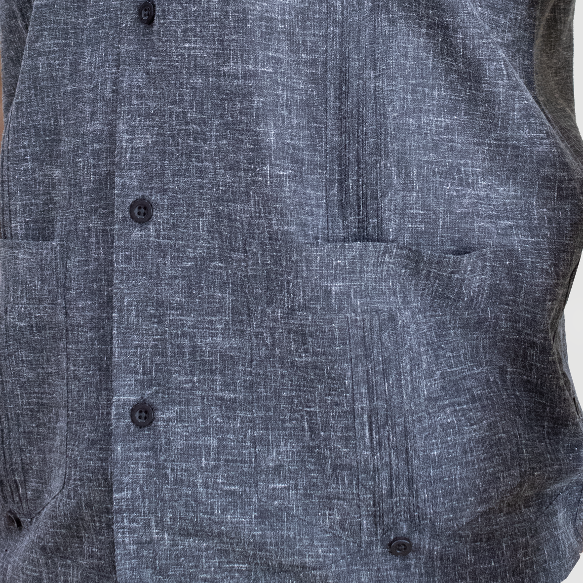 Detalle de los pliegues artesanales de la guayabera gris oscuro