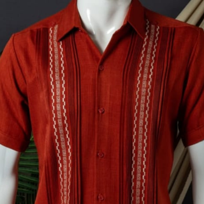 Detalle de los pliegues y bordados de la guayabera roja.
