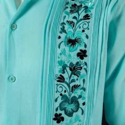 Detalle de los pliegues y bordados de la guayabera verde agua.