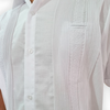Detalle de pliegues y bordado en guayabera blanca de lino