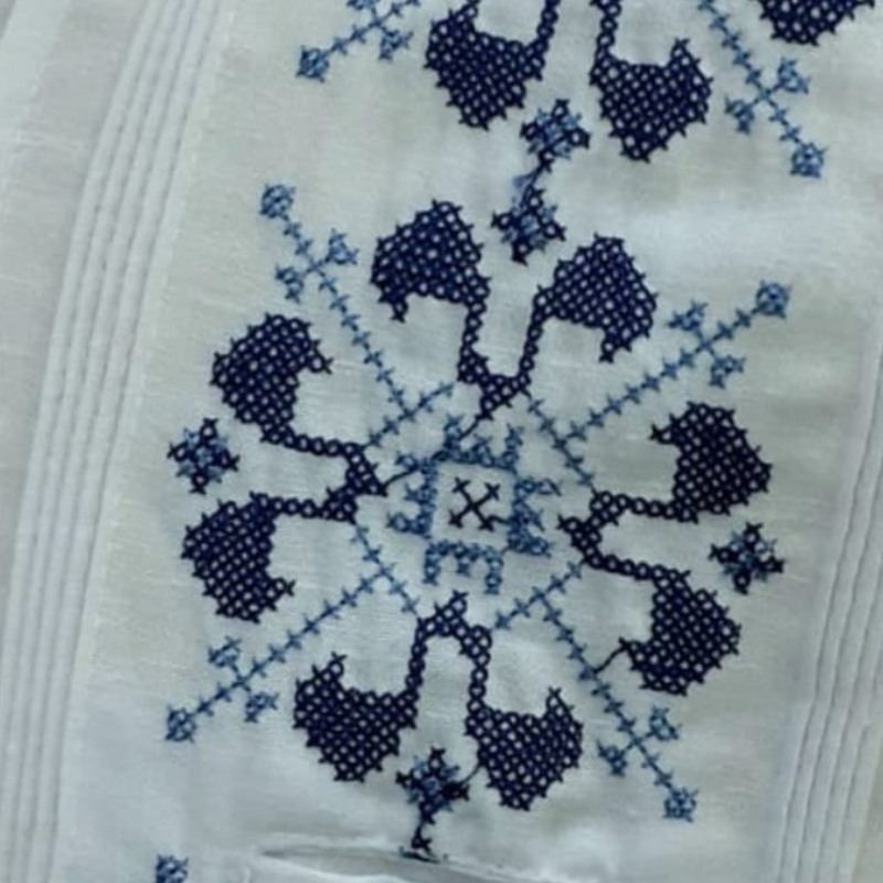 Detalle del bordado azul tradicional en guayabera blanca