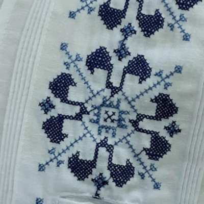 Detalle del bordado azul tradicional en guayabera blanca