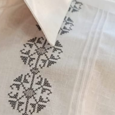 Detalle del bordado gris en guayabera blanca elegante
