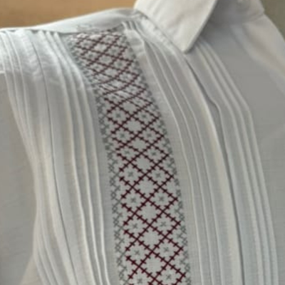 Detalle del bordado tradicional gris y rojo en guayabera presidencial