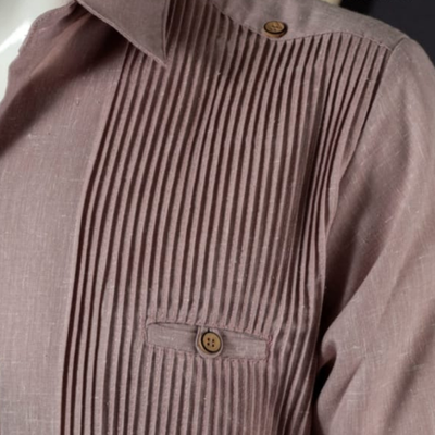 Detalle del tejido de algodón y botones discretos en guayabera presidencial palo de rosa