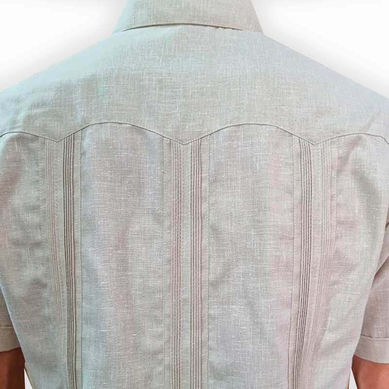 Hombre luciendo guayabera beige estilo cubano en un evento elegante

