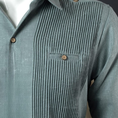 Guayabera presidencial verde doblada, prenda de algodón premium con acabado elegante y corte clásico.