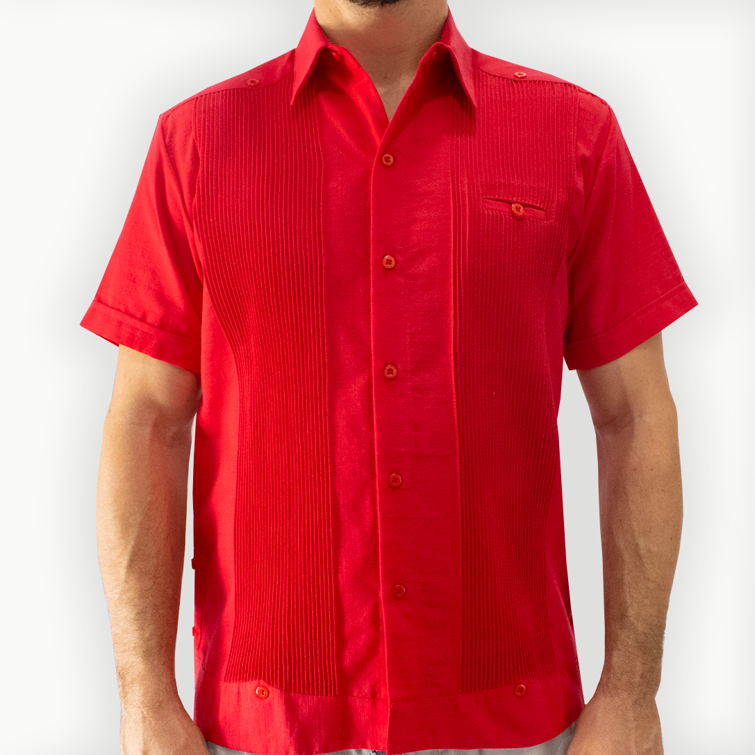 Hombre con guayabera color rojo caminando en evento tropical

