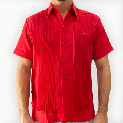 Hombre con guayabera color rojo caminando en evento tropical