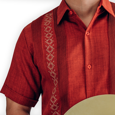 Hombre con guayabera shedrón y pantalones blancos en exterior
