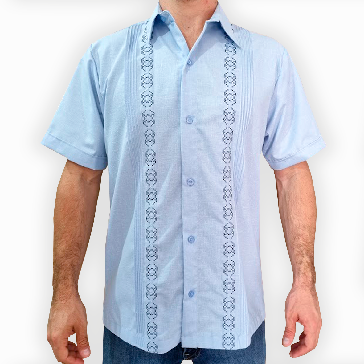 Hombre luciendo guayabera azul cielo bordada de manga corta al aire libre

