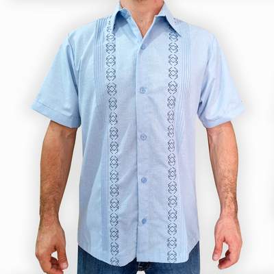 Hombre luciendo guayabera azul cielo bordada de manga corta al aire libre