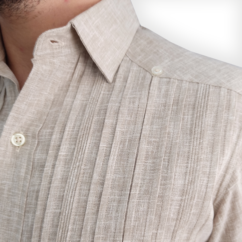 Hombre usando guayabera color beige en ambiente tropical