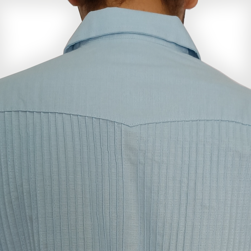 Hombre vistiendo camisa guayabera azul cielo con pantalón claro