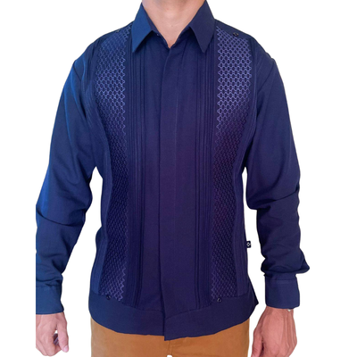 Modelo luciendo guayabera azul navy combinada con pantalones beige.