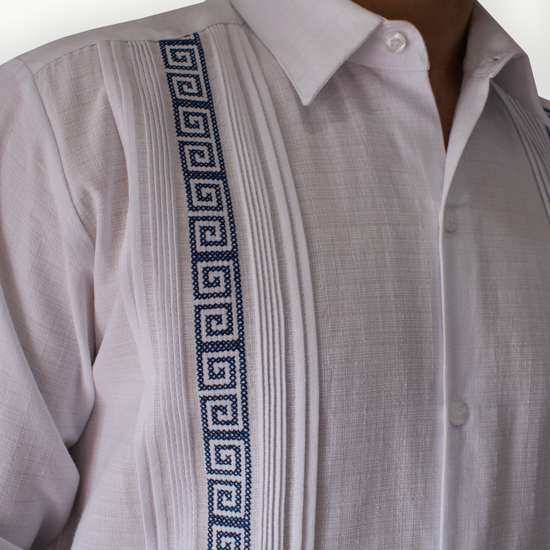 Modelo luciendo guayabera blanca bordado azul en evento formal