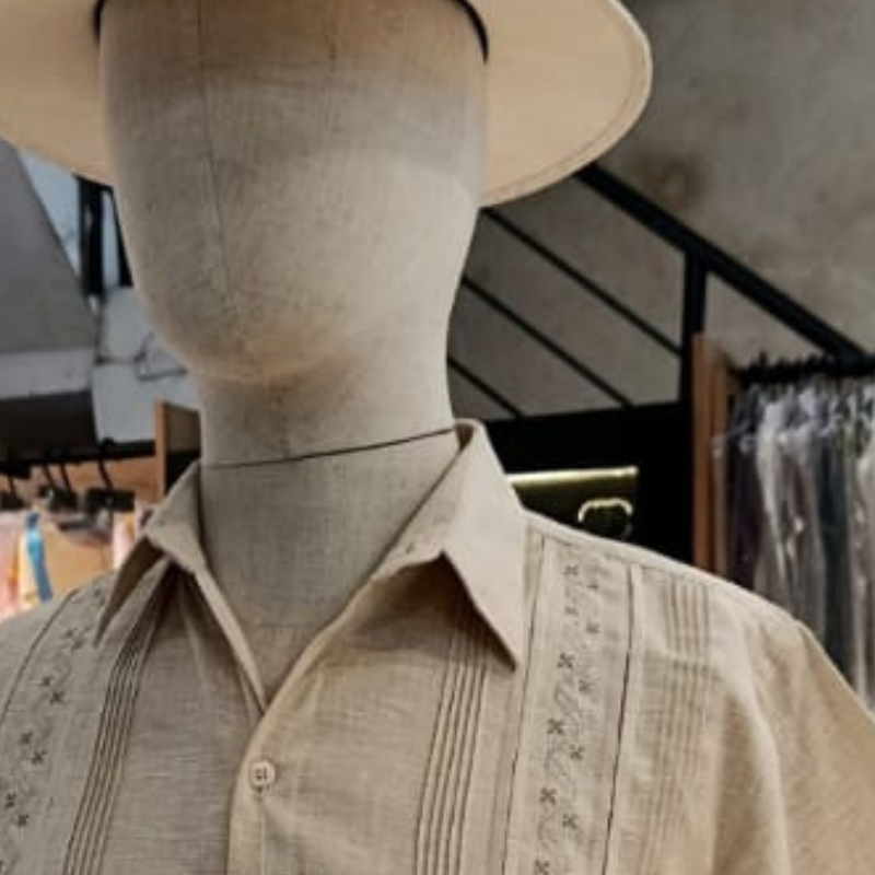 Modelo usando guayabera beige bordada en evento tropical