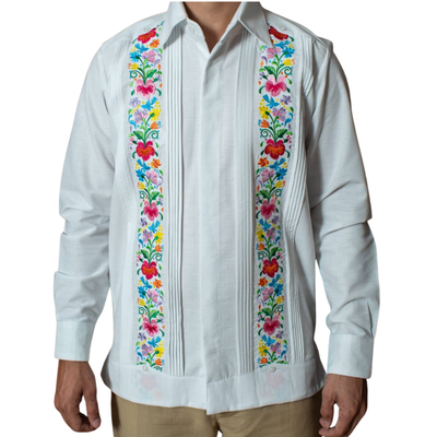 Modelo usando guayabera blanca bordada con flores en evento tropical
