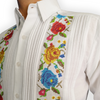 Modelo usando guayabera blanca bordada frente a paisaje natural
