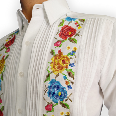 Modelo usando guayabera blanca bordada frente a paisaje natural