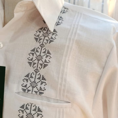 Modelo usando guayabera blanca bordada gris manga corta