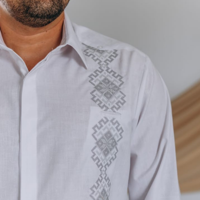 Modelo usando guayabera blanca bordada gris manga larga