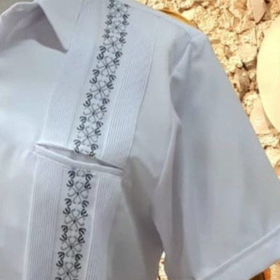 Modelo usando guayabera blanca bordada verde manga corta
