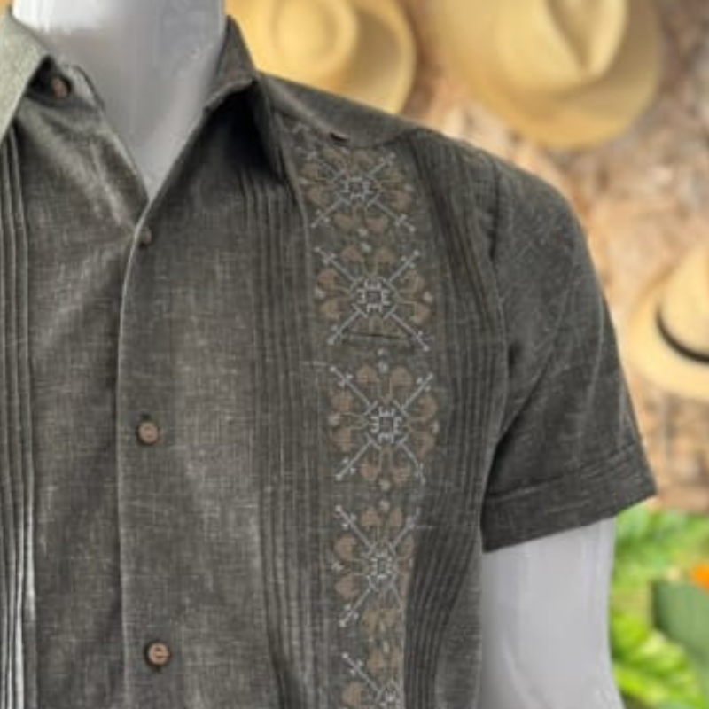 Modelo usando guayabera gris bordada en evento tropical