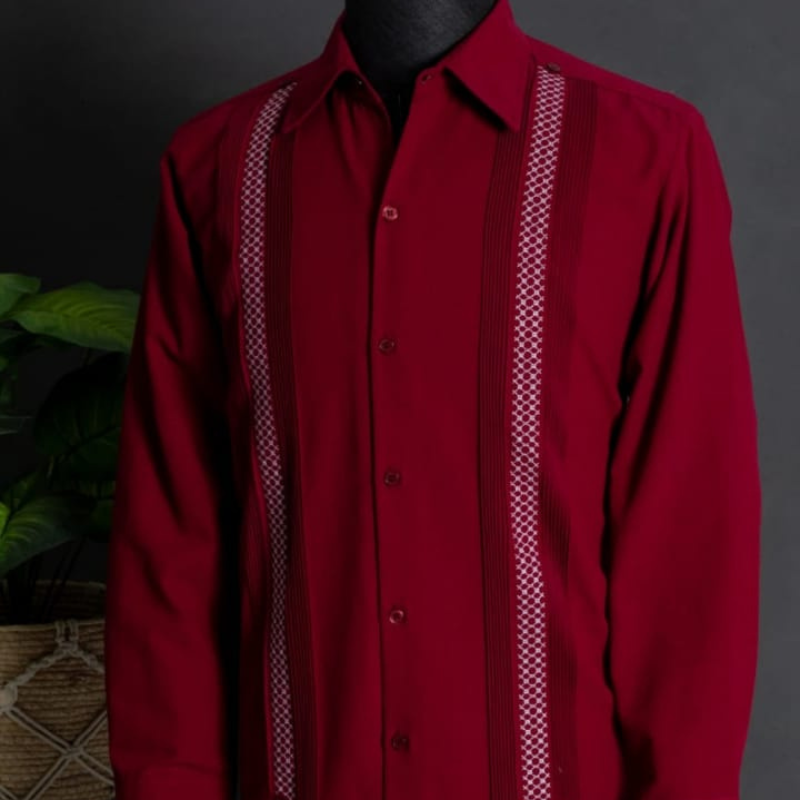 Modelo usando guayabera rojo cereza combinada con pantalones beige.