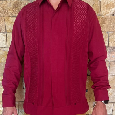 Modelo usando guayabera rojo vino combinada con pantalones beige.
