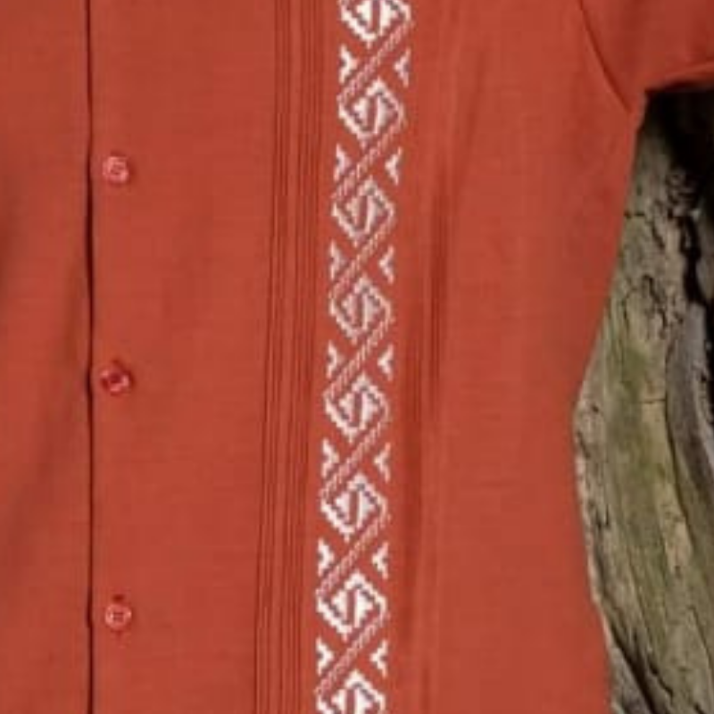 Modelo usando guayabera terracota bordada con pantalones beige.