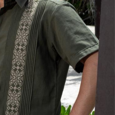 Modelo usando guayabera verde militar combinada con pantalones beige