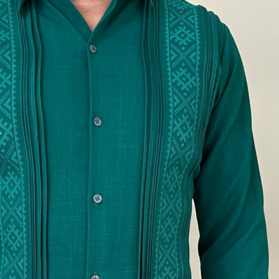Modelo usando guayabera yucateca verde con pantalones beige.
