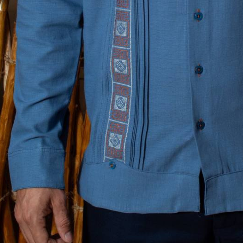 Modelo vistiendo guayabera azul bordada con pantalones beige