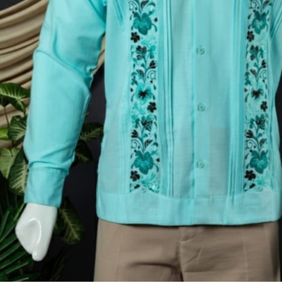 Modelo vistiendo guayabera verde agua combinada con pantalones beige.
